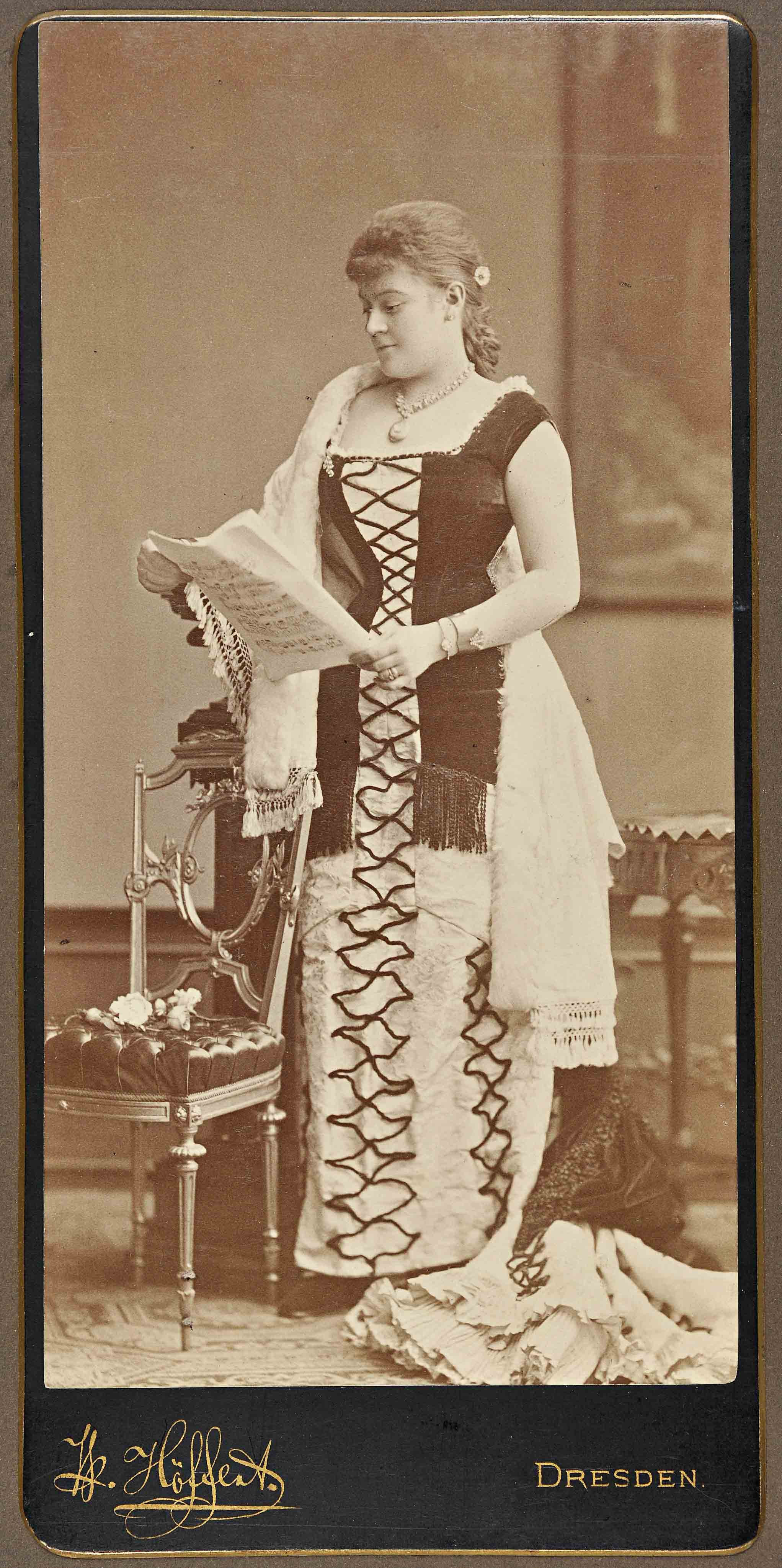 Fotoportrait einer Frau, die ein Notenblatt in der Hand hält